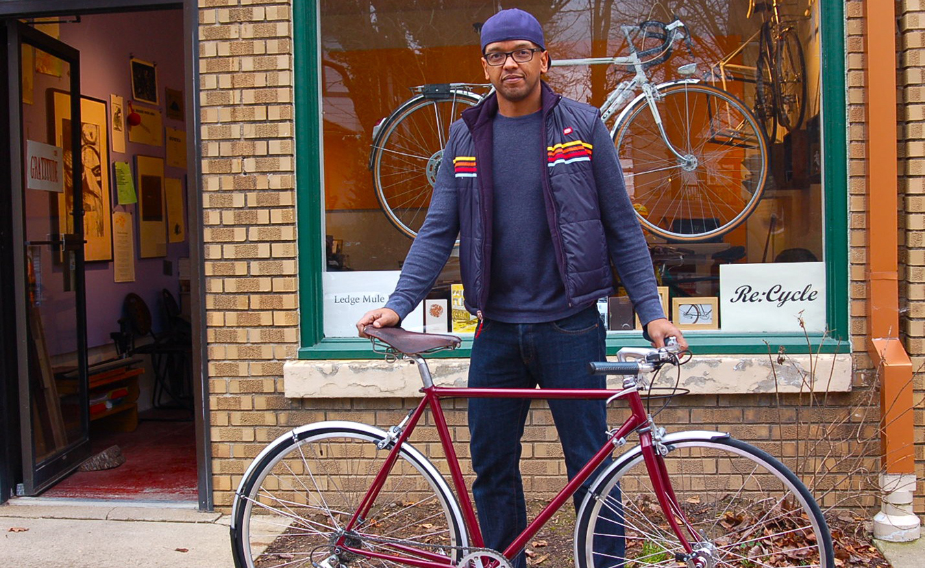 Wright with Welsch’s refurbished bike — from a rusty, old road bike to a sleek, new city bike — outside of his storefront, Re:Cycle, in the I. Fell building at West 4th and South Rogers streets. | Photo by Sam Sveen