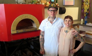 Adam (left) and Alicia Sweet, owners of King Dough pizza, stand next to their Italian brick oven in their brick-and-mortar location on the downtown Square. | Photo by Lynae Sowinski