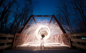 Nathan Clark spins steel wool on the Clear Creek Trail. Clark created this image by packing steel wool into a whisk, attaching it to a dog leash, lighting it on fire, and spinning it while using a long exposure. | Photo by Nathan Clark
