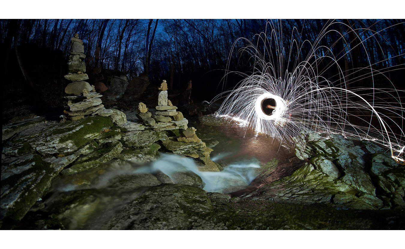 This photo was taken by packing steel wool into a whisk, attaching it to a dog leash, lighting it on fire, and spinning it while using a long exposure. | Photo by Nathan Clark