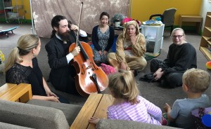 Kim Carballo (left) and Miles Edwards (second to the left) teach children about the cello. | Courtesy photo