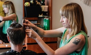 Cathleen Paquet, a hairstylist at Hairstream Studio, styles a client's hair. She says this trade allows her "to connect with other people really deeply." | Photo by Mark Anthony Kathurima