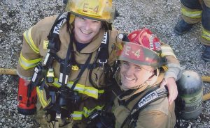 Jean Magrane (left), who became Bloomington's first woman firefighter in 1987, with Greg Lucas at the “Jiffy Treat training day” in 2006. The fire department is often allowed to use condemned buildings for training purposes before the buildings are destroyed, such as the old Jiffy Treat on Kirkwood Avenue. | Courtesy photo