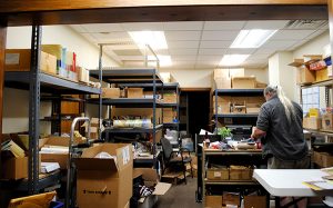 Jerry Iverson, The Language Conservancy’s customer support representative, sifts through boxes of Booklets, DVDs, flashcards, and other materials produced at the business’s Bloomington-based headquarters.