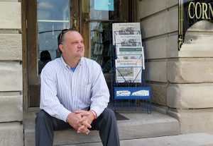 Richey sits on the steps of The Book Corner, which resides in a historic building, on the downtown Square. | Limestone Post