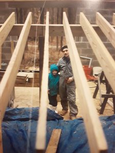 Lana Cruce with her father, as he builds the family home at May Creek Farm in the late 1980s. | Courtesy photo