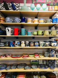 Global Gifts carries beautiful ceramics from all around the world. There are plenty of feline-themed options for the cat people in your life, kitchen and tableware for the gracious dinner hosts, a medley of mugs and pots for the coffee and tea drinkers, and even ceramic cell phone amplifiers for the podcast enthusiasts (yes, that’s a thing — can you spy the blue vessel that looks like it has a face?). Pottery from the West Bank, pictured on the lower two shelves, is always a favorite; The little bowls can be used to serve snacks and sauces or store jewelry and trinkets. The swirled Phonetician glass on the top shelf also hails from the West Bank — from Hebron Glass, a glass-blowing factory that has been in business since 1890.