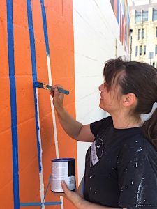 Eva Allen painted the mural 'Love This City' at the Mother Bear's Pizza east-side location last summer. She also painted 'You Belong Here' in Peoples Park | Limestone Post