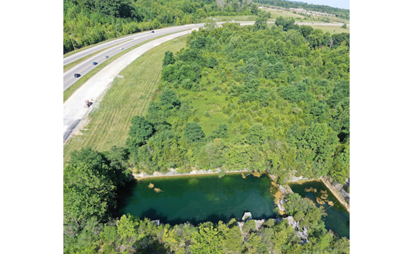 The view looking west along State Road 46. Long Hole (bottom) was a popular swimming hole for many longtime residents. A parking lot is proposed for the wooded area in the top right of the photo. | Photo by Geoff McKim