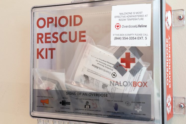 Bloomington and Monroe County have already received their first payments from the first opioid settlement, but none of it has been spent. Many health service providers wonder where the money will go. NaloxBoxes, like the one above at the IU Health Center, are among the uses approved by the state as part of the settlement documents. | Photo by Benedict Jones