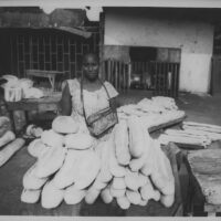La Porteuse de Pain (The Bread Peddler), Conakry, Guinea, 2008, Gelatin Silver Print. Woman sells bread to make a living on the streets of Conakry.