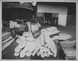 La Porteuse de Pain (The Bread Peddler), Conakry, Guinea, 2008, Gelatin Silver Print. Woman sells bread to make a living on the streets of Conakry.