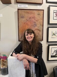 Jaime Sweany, owner of Juniper Art Gallery, after hanging the work of Rejon Taylor for the gallery’s Regional Artist Exhibit. | Limestone Post