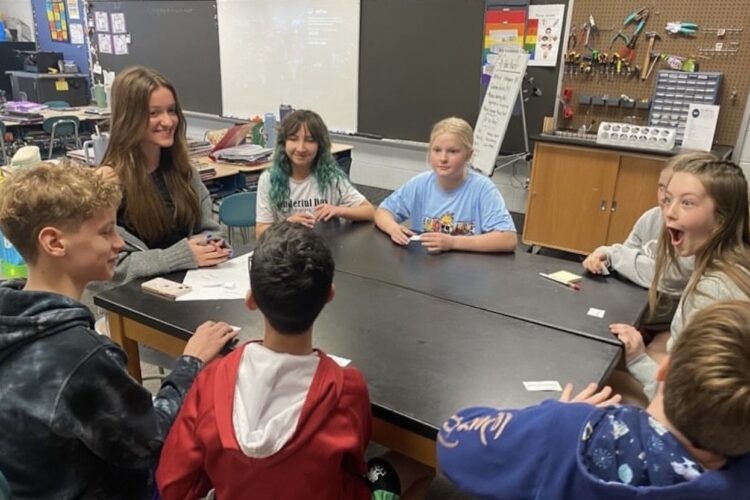 Sophia Craiutu (far left in gray sweater), a senior at Bloomington High School North, discusses current events from around the world with younger students as part of Global Learners, an organization she co-founded. | Courtesy photo