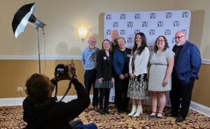 Limestone Post writers get their photos taken by Benedict Jones, an LP contributor and a news anchor at WFHB Community Radio, at the 2023 “Best in Indiana” Journalism Contest hosted by the Indiana Pro Chapter of the Society of Professional Journalists. Those being photographed are (l-r) Steve Hinnefeld, Haley Miller, Steven Higgs, Rebecca Hill, Christine Brackenhoff, Christina Avery, and Michael G. Glab. | Limestone Post