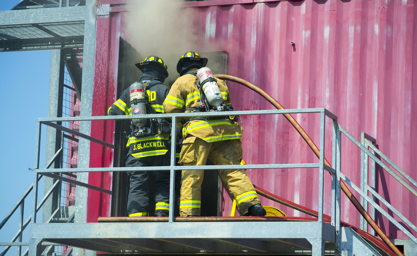 Winter in Indiana is prime season for house fires, but the Bloomington Fire Department’s Fire Prevention Division works year-round to reduce the risk of fires and promote fire safety. Above, firefighters train at the Public Safety Training facility on South Walnut Street. | Photography by Nick Bauer